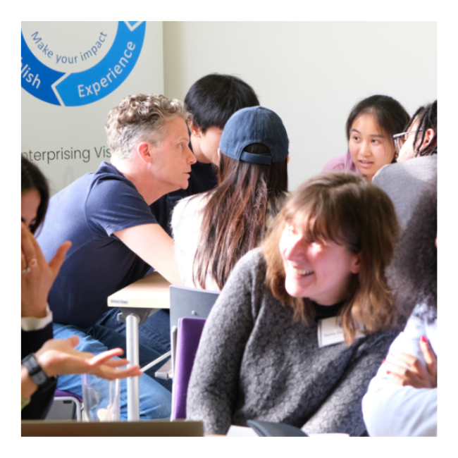 Mentor and students around table talking and smiling