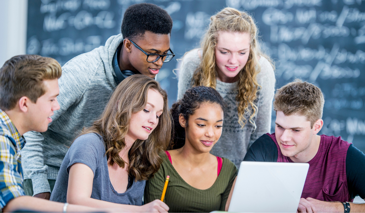 Diverse fgroup of students working around a laptop