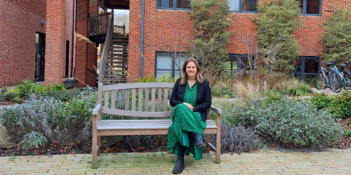 Annna Smith sitting on a bench in Lucy Cavendish's courtyard