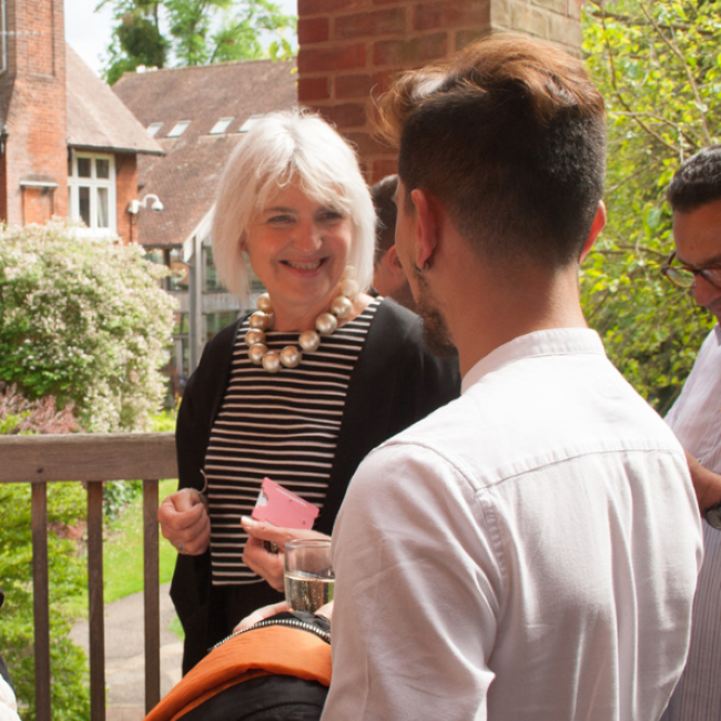 two people chatting on dining hall balcony