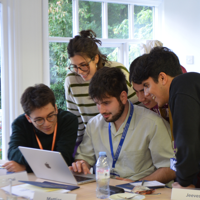 Students working together around laptop